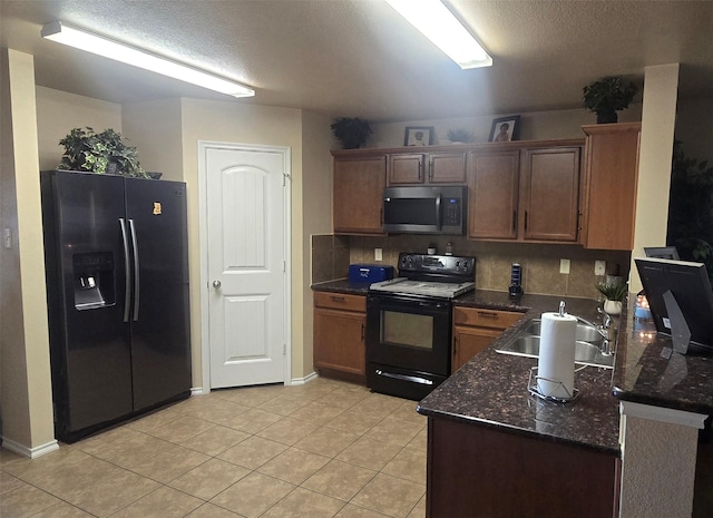 kitchen with black electric range oven, sink, dark stone countertops, light tile patterned floors, and refrigerator with ice dispenser