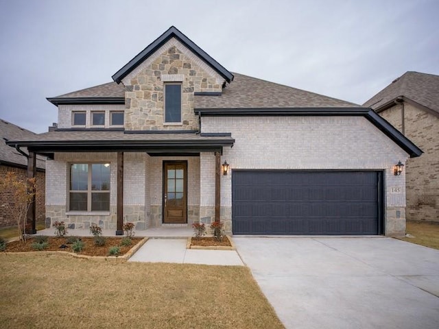 view of front of home featuring a garage, a front lawn, and covered porch