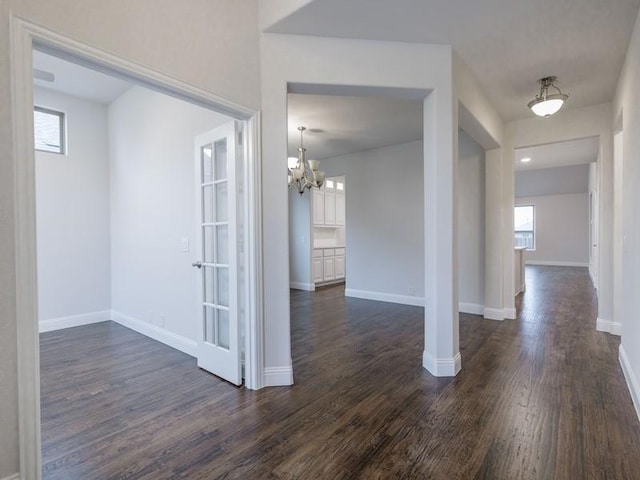 interior space with a notable chandelier and dark wood-type flooring