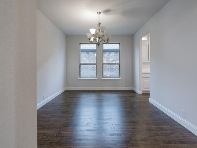 unfurnished room with an inviting chandelier and dark wood-type flooring