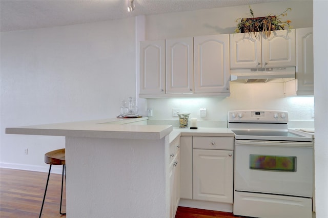 kitchen with a breakfast bar area, dark hardwood / wood-style floors, white range with electric stovetop, white cabinets, and kitchen peninsula