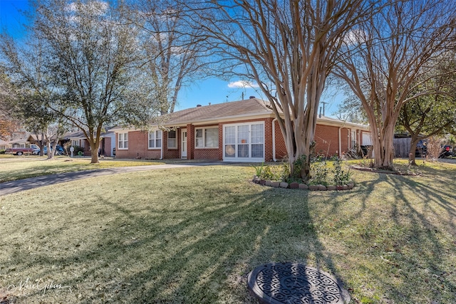 ranch-style home featuring brick siding and a front lawn