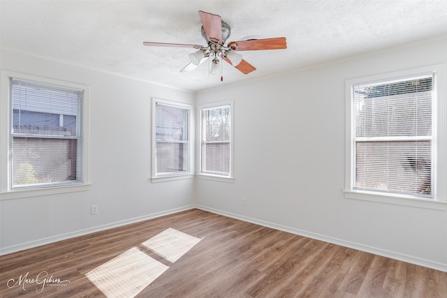 empty room with hardwood / wood-style floors, a textured ceiling, and ceiling fan