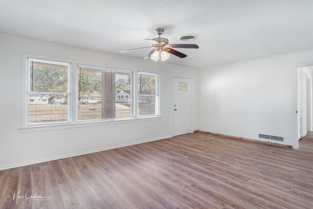 unfurnished living room featuring ornamental molding, ceiling fan, and light hardwood / wood-style floors