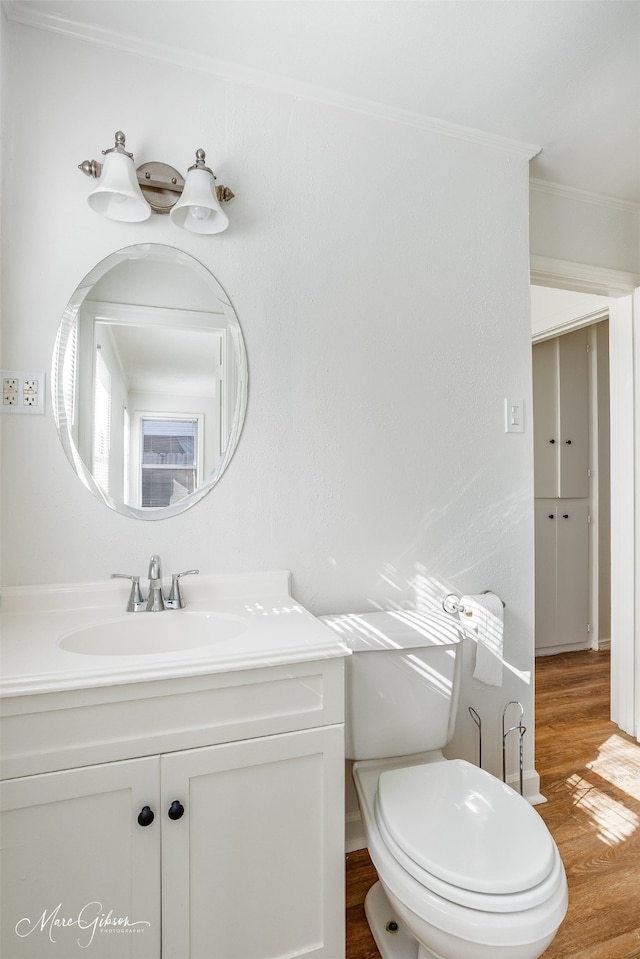 bathroom with vanity, hardwood / wood-style floors, ornamental molding, and toilet