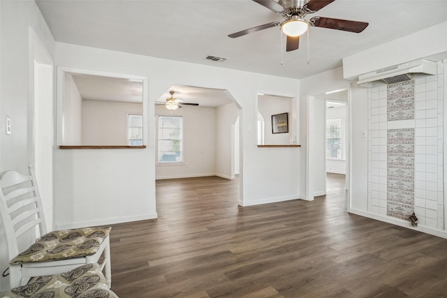 unfurnished living room with dark wood-type flooring and ceiling fan