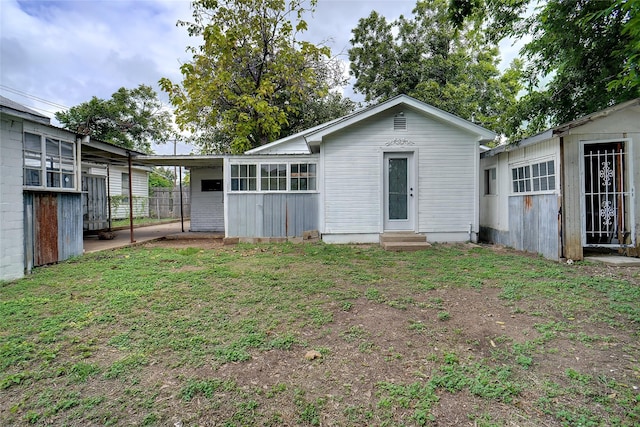 rear view of house featuring a yard