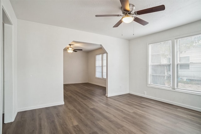 unfurnished room with a healthy amount of sunlight, a textured ceiling, and dark hardwood / wood-style floors