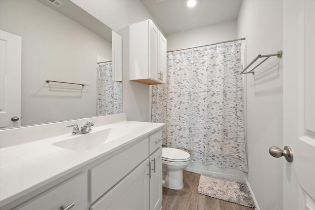 bathroom featuring wood-type flooring, vanity, and toilet