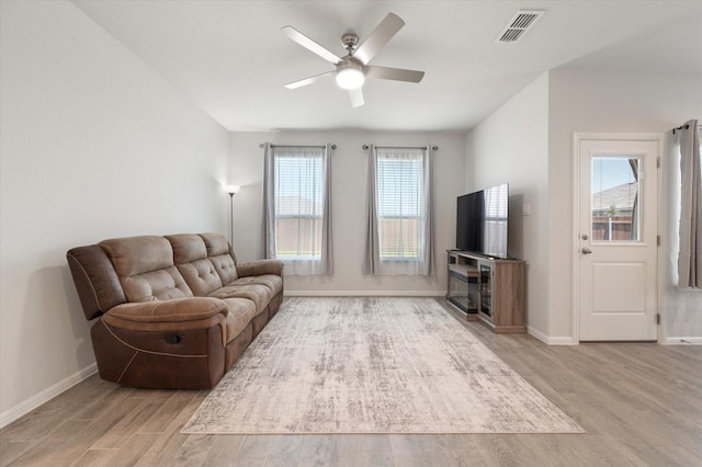 living room featuring ceiling fan, a healthy amount of sunlight, and light wood-type flooring