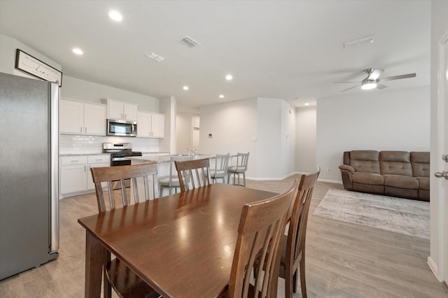 dining room with light wood-type flooring and ceiling fan