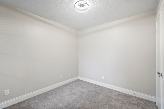 empty room with carpet floors and a textured ceiling