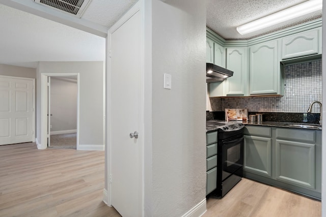 kitchen featuring sink, green cabinetry, light wood-type flooring, electric range, and backsplash