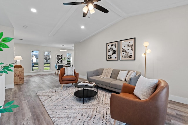 living room featuring wood-type flooring, lofted ceiling with beams, and ceiling fan