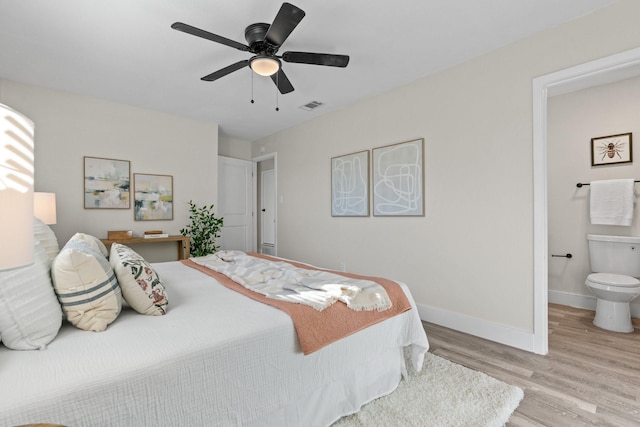 bedroom with ceiling fan, ensuite bath, and light hardwood / wood-style flooring