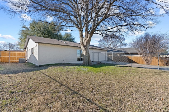 rear view of property featuring cooling unit and a lawn