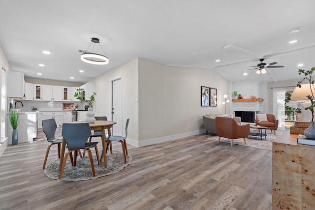 dining space featuring sink, vaulted ceiling, light hardwood / wood-style floors, and ceiling fan