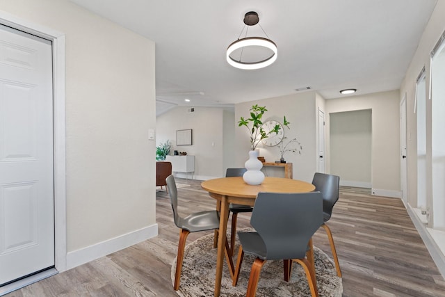 dining area with hardwood / wood-style flooring and lofted ceiling