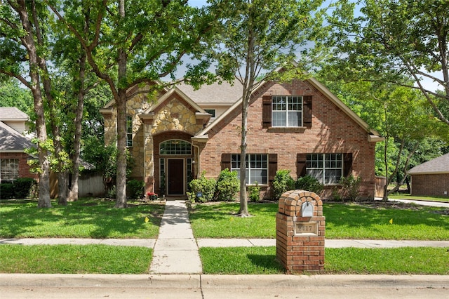 1417 Flying Jib Dr, Azle, TX 76020 - traditional-style house featuring a front yard, brick siding, and stone siding