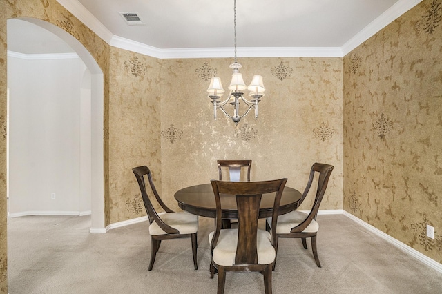 dining space featuring crown molding, a chandelier, and carpet