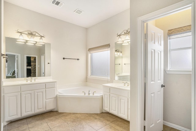 bathroom featuring a bathing tub, vanity, and tile patterned floors