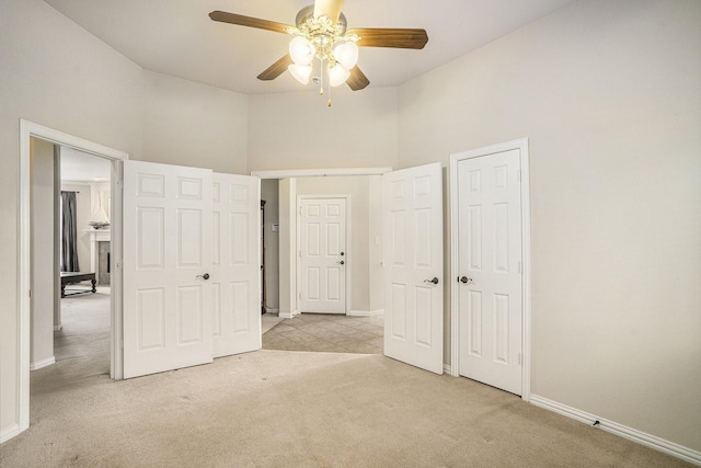 unfurnished bedroom with light colored carpet and ceiling fan