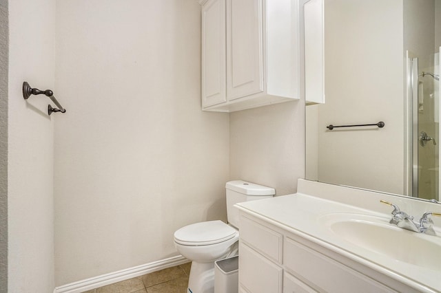 bathroom featuring tile patterned flooring, vanity, a shower with door, and toilet