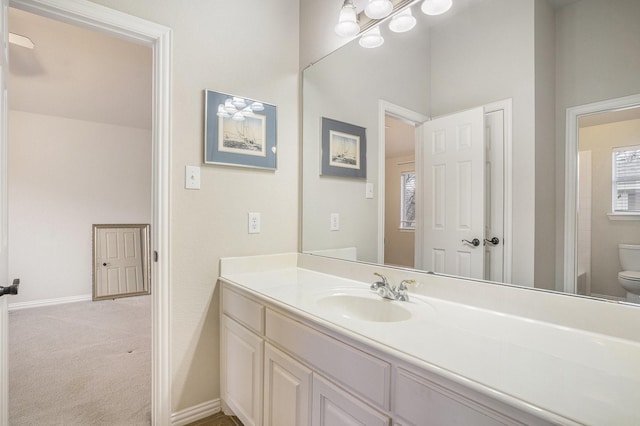 bathroom featuring a healthy amount of sunlight, vanity, and toilet