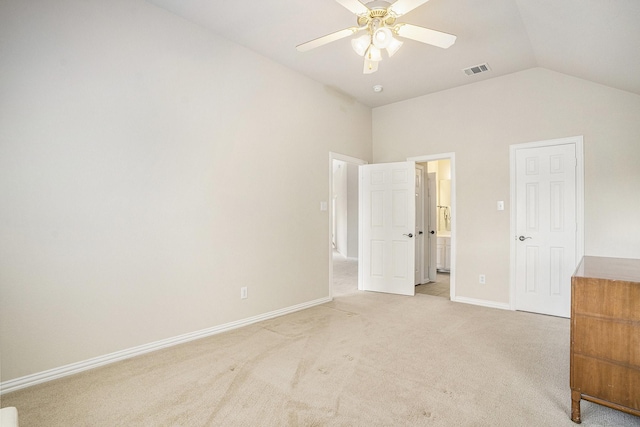 unfurnished bedroom featuring lofted ceiling, light carpet, connected bathroom, and ceiling fan