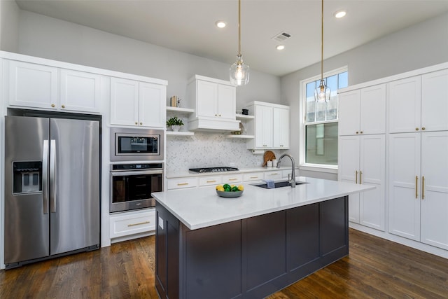 kitchen featuring appliances with stainless steel finishes, dark hardwood / wood-style floors, tasteful backsplash, sink, and hanging light fixtures