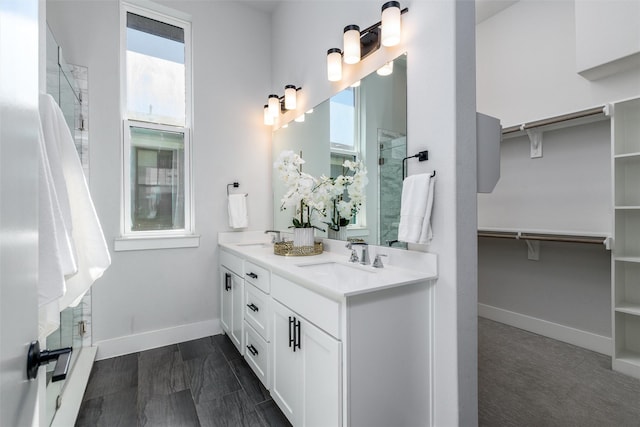 bathroom featuring a shower with door and vanity