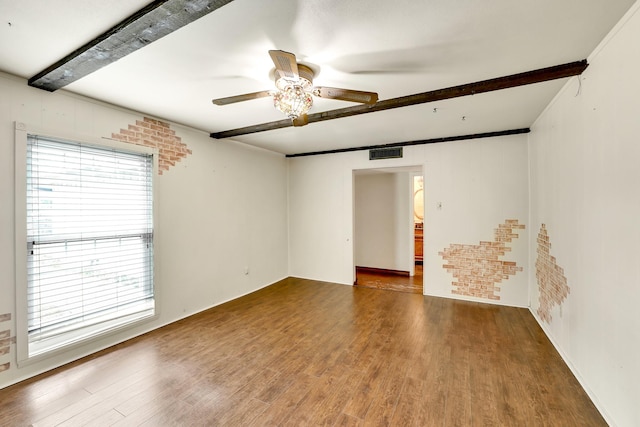 spare room with beamed ceiling, ceiling fan, brick wall, and hardwood / wood-style flooring