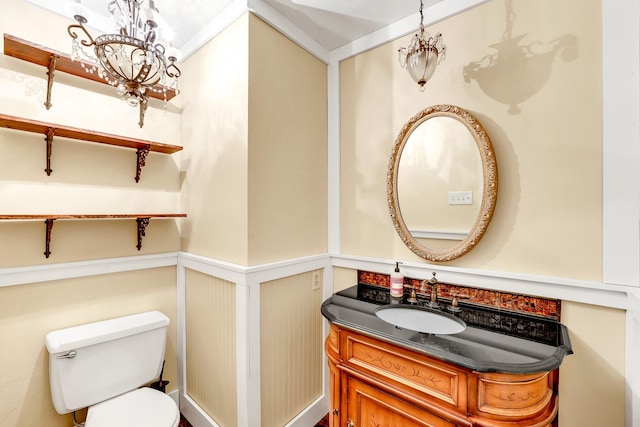 bathroom with vanity, an inviting chandelier, and toilet