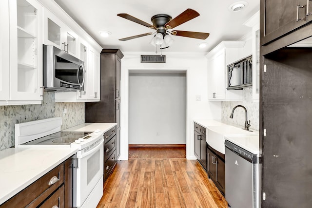 kitchen featuring dark brown cabinetry, stainless steel appliances, and white cabinets