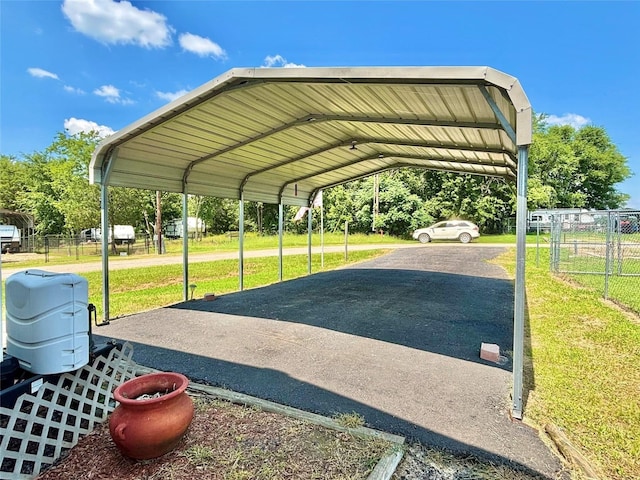 view of parking featuring a yard and a carport