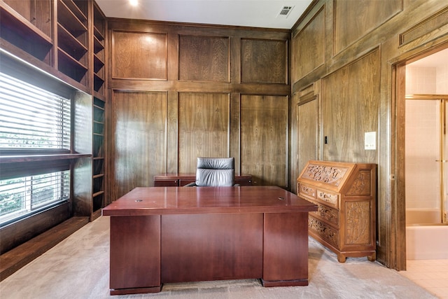 office space with light colored carpet and wood walls