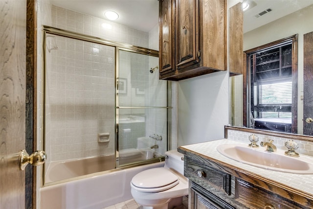 full bathroom with vanity, enclosed tub / shower combo, and toilet