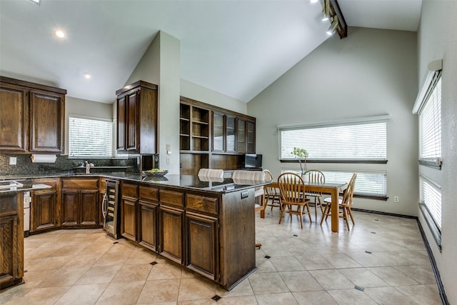 kitchen with wine cooler, light tile patterned floors, tasteful backsplash, and high vaulted ceiling