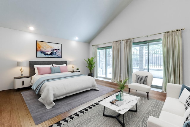 bedroom featuring hardwood / wood-style flooring, access to outside, and high vaulted ceiling