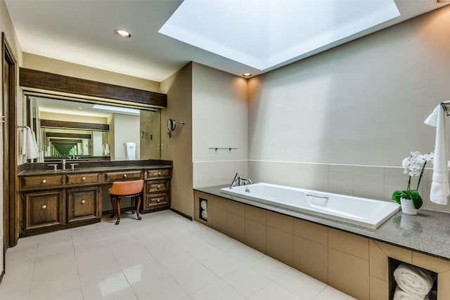 bathroom featuring tile patterned flooring, vanity, and a relaxing tiled tub