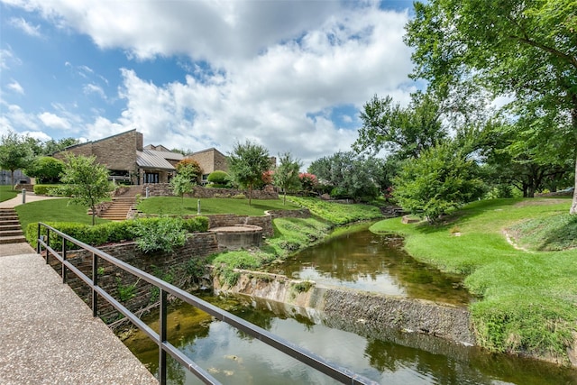 view of property's community featuring a water view and a lawn