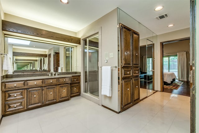 bathroom with vanity, tile patterned flooring, and a shower with shower door