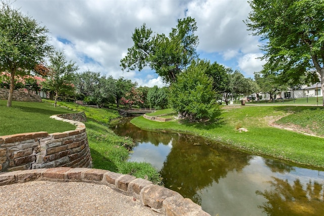 view of property's community with a water view and a yard