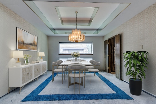 carpeted dining room featuring an inviting chandelier and a tray ceiling