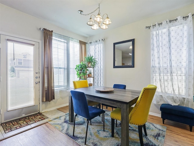 dining space featuring hardwood / wood-style flooring, plenty of natural light, and a notable chandelier