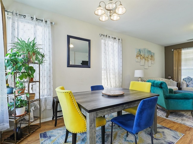 dining area featuring hardwood / wood-style flooring and an inviting chandelier