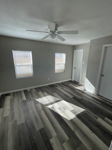 spare room with dark wood-type flooring and ceiling fan