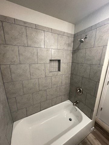 bathroom with wood-type flooring and tiled shower / bath combo