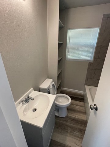 full bathroom featuring vanity, wood-type flooring, shower with separate bathtub, and toilet