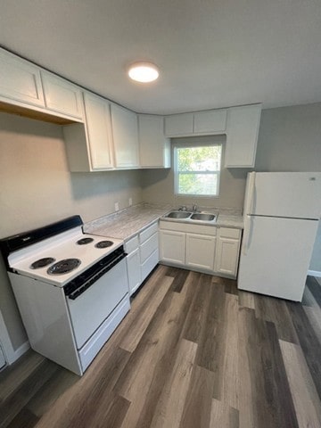 kitchen featuring white cabinetry, white appliances, dark hardwood / wood-style floors, and sink